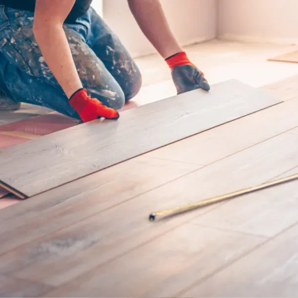 Worker installing hardwood | Flooring By Design