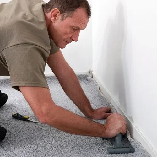Worker installing carpet | Flooring By Design